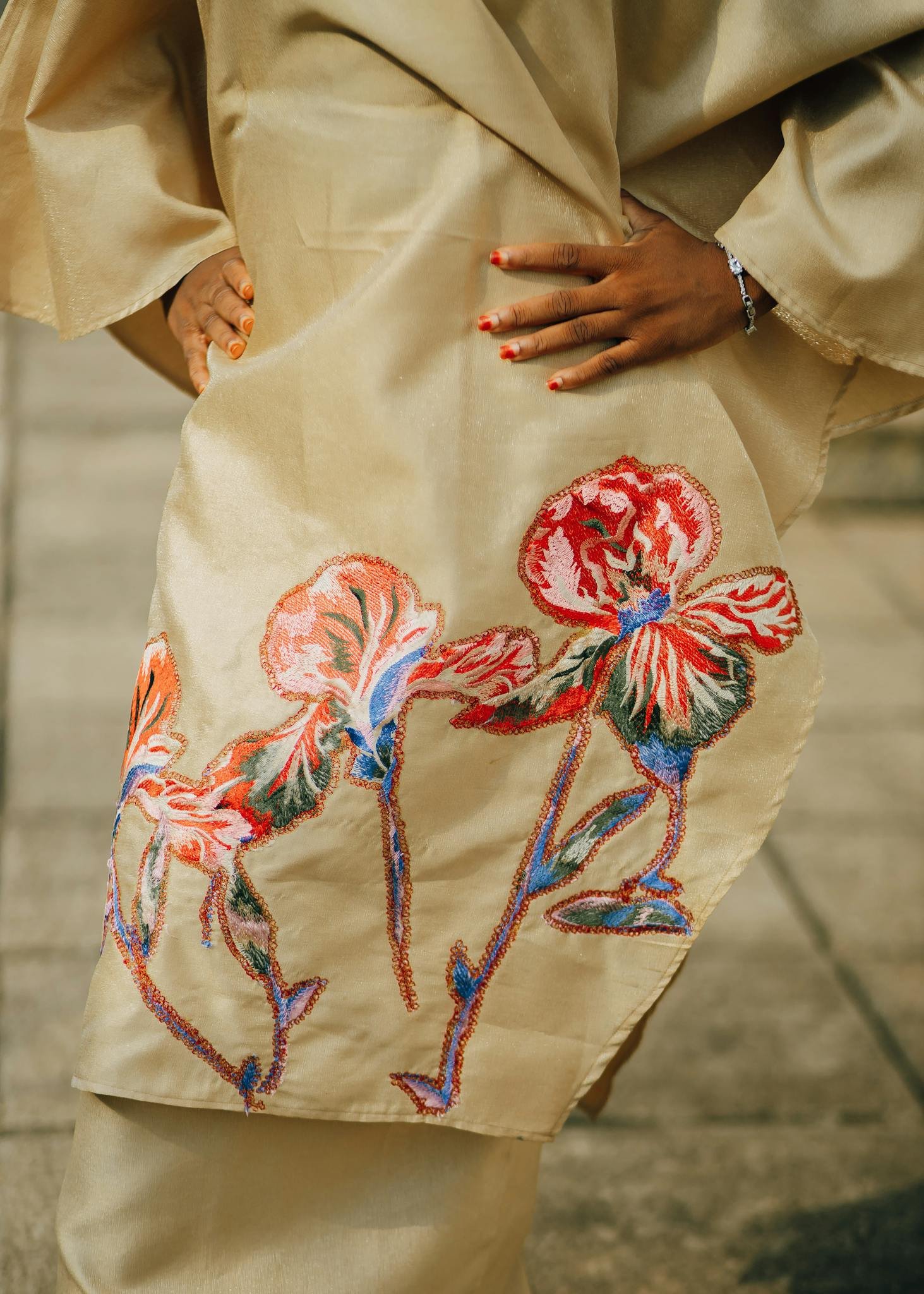 Close-up of a beige dress featuring vibrant floral embroidery, exuding elegance.